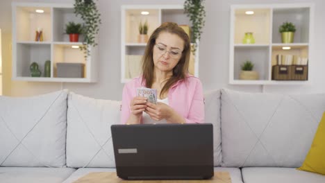 Woman-counting-money-at-laptop.